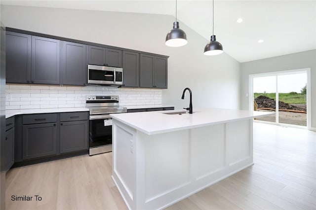 kitchen with backsplash, light wood-type flooring, appliances with stainless steel finishes, sink, and lofted ceiling