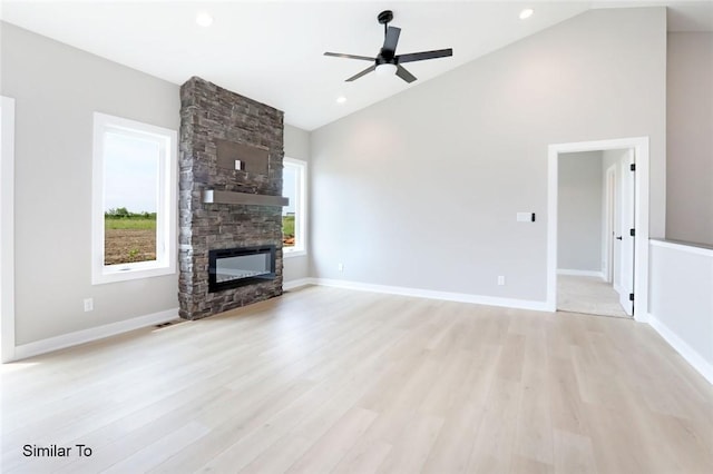 unfurnished living room with a stone fireplace, baseboards, and light wood finished floors