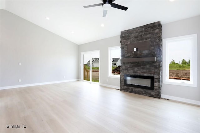 unfurnished living room featuring baseboards, lofted ceiling, a fireplace, and light wood finished floors