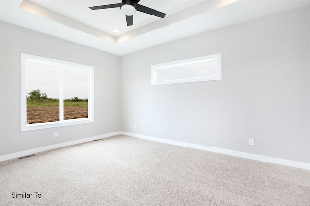 2412 NE 6th St, Grimes, IA 50111 - carpeted empty room featuring visible vents, ceiling fan, a raised ceiling, and baseboards
