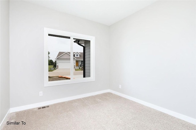 carpeted spare room featuring baseboards and visible vents