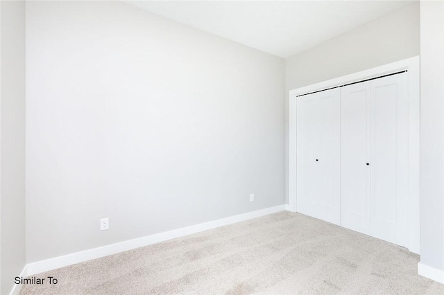 unfurnished bedroom with a closet, baseboards, and carpet floors