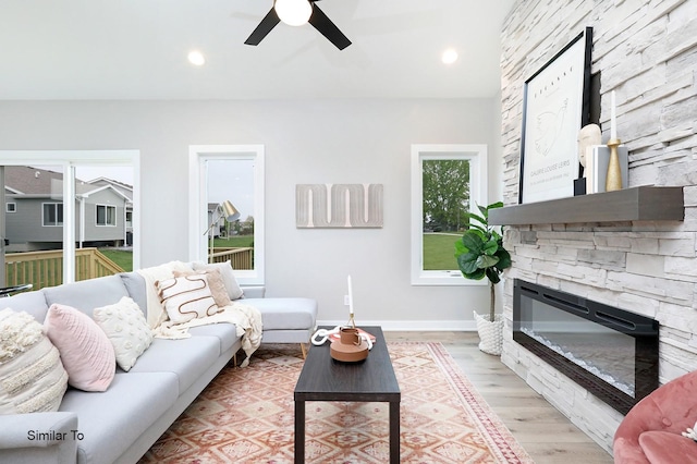 living room featuring recessed lighting, a fireplace, light wood finished floors, and ceiling fan