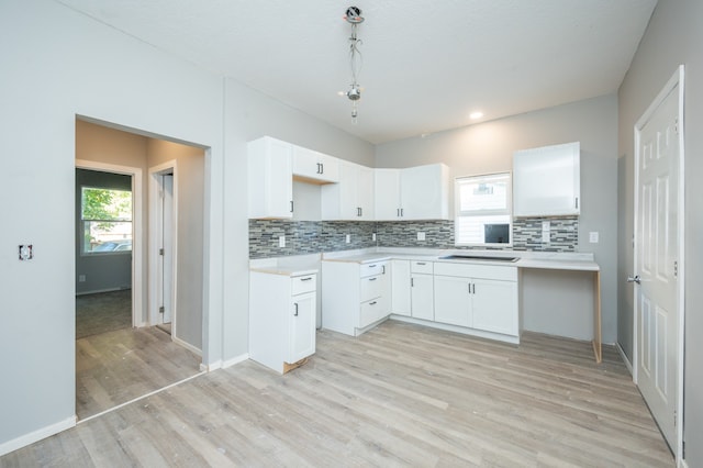 kitchen featuring light hardwood / wood-style flooring, hanging light fixtures, and white cabinetry