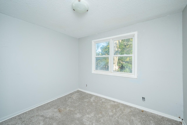 1125 Clinton Ave, Des Moines, IA 50313 - empty room with carpet flooring, baseboards, and a textured ceiling