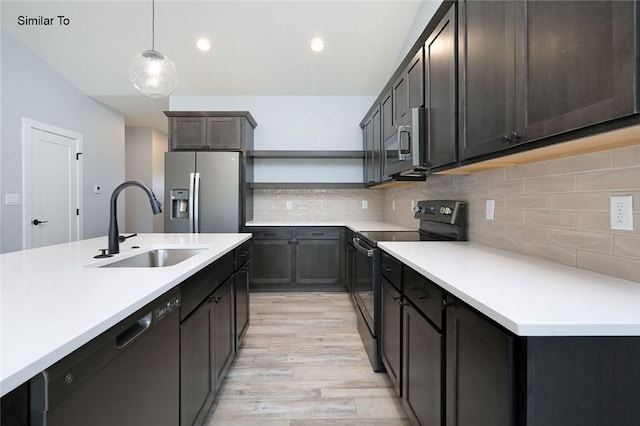 kitchen with a sink, light countertops, light wood-style flooring, and stainless steel appliances