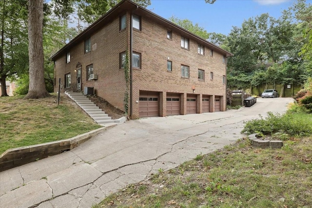 view of side of home with brick siding and central AC unit