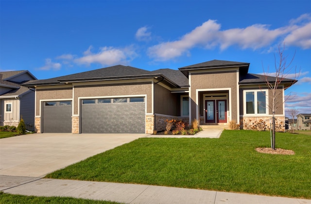 prairie-style home featuring a garage and a front lawn