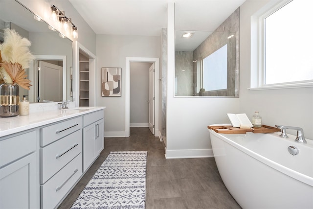 bathroom featuring plus walk in shower, vanity, and wood-type flooring