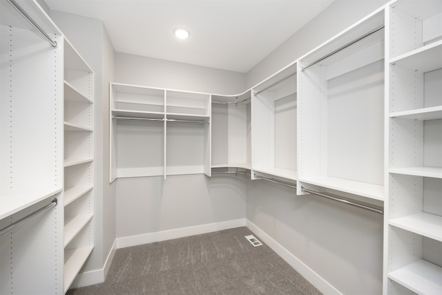 spacious closet featuring dark carpet