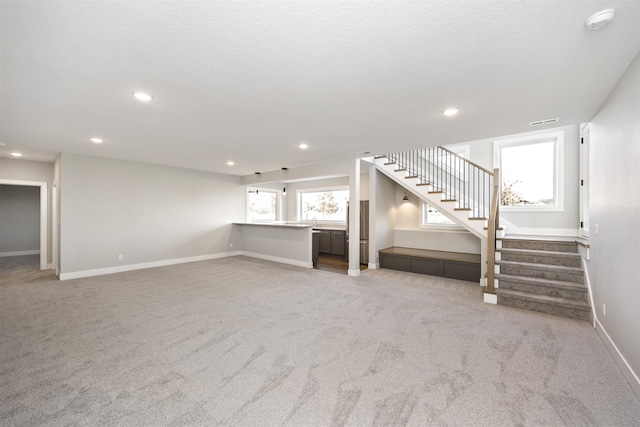 unfurnished living room featuring light colored carpet