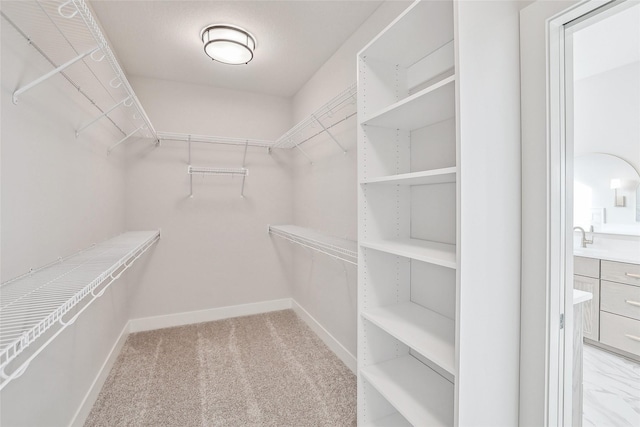 walk in closet featuring light carpet