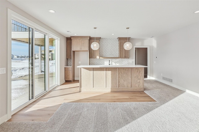 kitchen with tasteful backsplash, a kitchen island, and hanging light fixtures