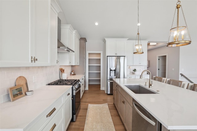 kitchen with pendant lighting, a large island, stainless steel appliances, white cabinets, and a sink