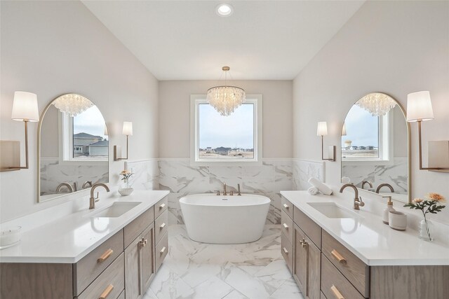 bathroom featuring a healthy amount of sunlight, marble finish floor, and a sink