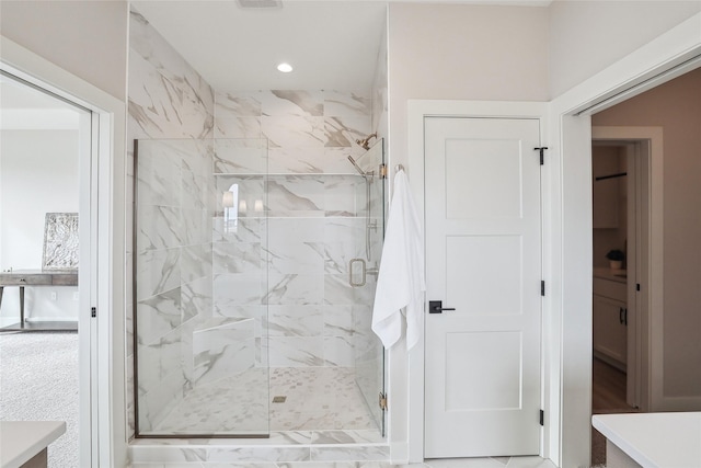 full bathroom with a marble finish shower and recessed lighting