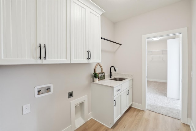 clothes washing area featuring cabinet space, a sink, light wood-type flooring, washer hookup, and electric dryer hookup