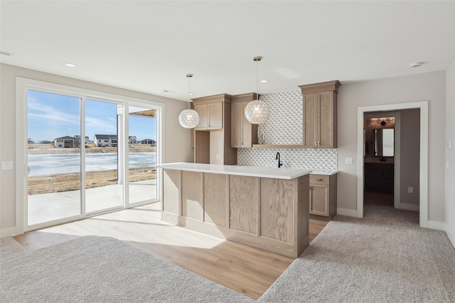 kitchen featuring tasteful backsplash, pendant lighting, light countertops, and baseboards