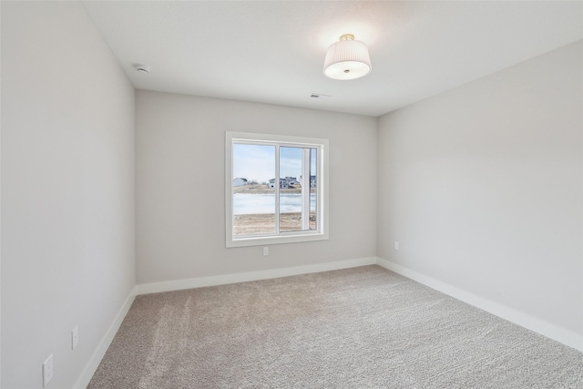 carpeted empty room with visible vents and baseboards