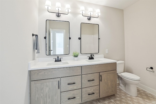 full bath featuring baseboards, a sink, toilet, and double vanity