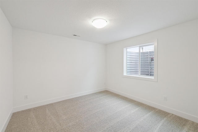 spare room with a textured ceiling and carpet floors