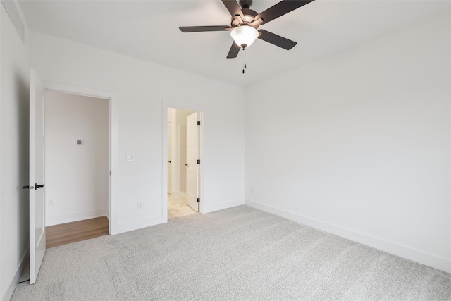 unfurnished bedroom featuring light carpet, connected bathroom, and ceiling fan