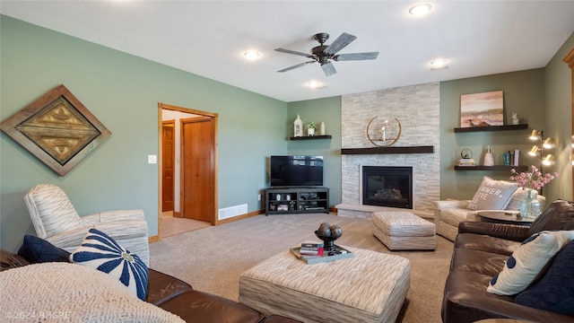 living room featuring ceiling fan, light colored carpet, and a fireplace