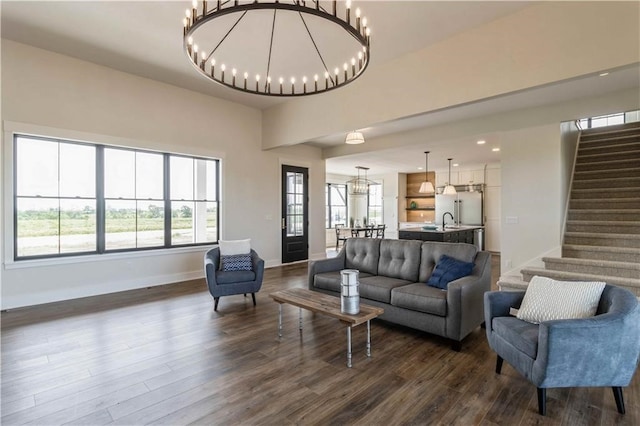 living room featuring a notable chandelier, dark hardwood / wood-style floors, and sink