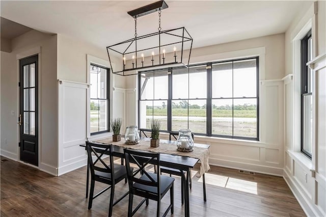 dining space featuring dark hardwood / wood-style floors and a chandelier