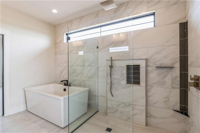 bathroom featuring a soaking tub, walk in shower, and recessed lighting