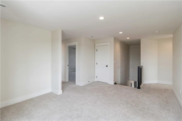 spare room with baseboards, visible vents, light colored carpet, and recessed lighting