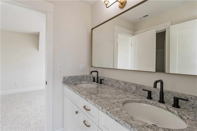 full bathroom featuring double vanity, a sink, visible vents, and baseboards