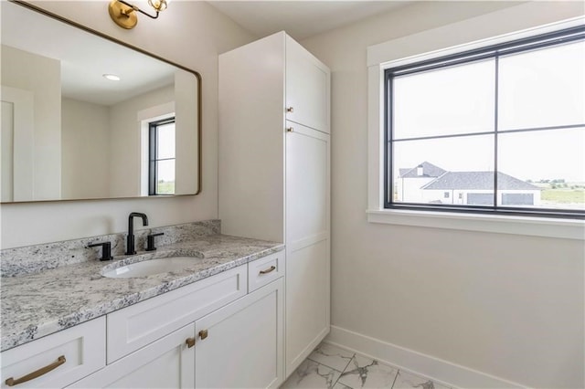 bathroom featuring marble finish floor, vanity, and baseboards