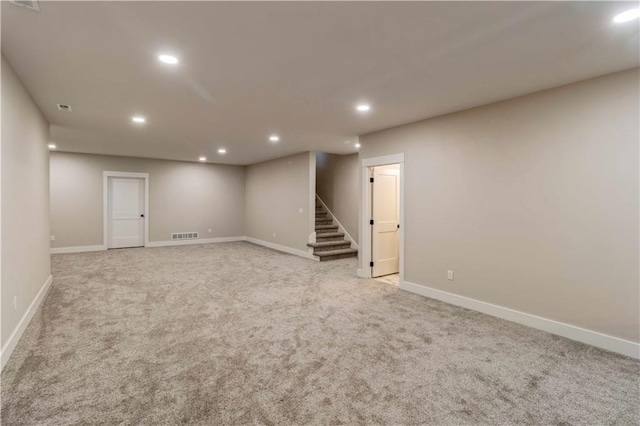 finished basement featuring recessed lighting, light colored carpet, baseboards, and stairs