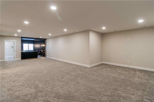 carpeted spare room featuring recessed lighting and baseboards