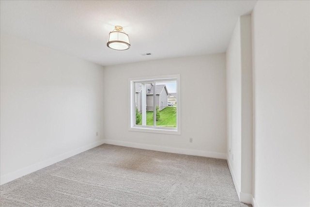 unfurnished room featuring carpet floors and baseboards