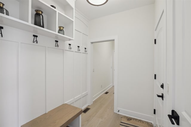 mudroom featuring light wood-style flooring, visible vents, and baseboards