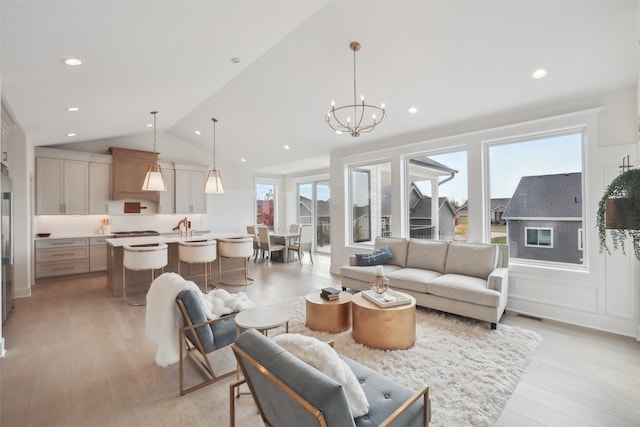 living area with lofted ceiling, plenty of natural light, and light wood-style flooring