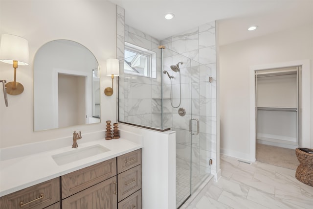 bathroom featuring recessed lighting, vanity, marble finish floor, a spacious closet, and a stall shower