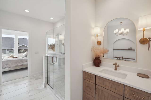 ensuite bathroom with ensuite bathroom, marble finish floor, a shower stall, and vanity