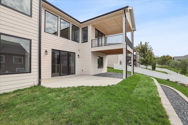 back of property featuring a yard, a patio area, fence, and a balcony