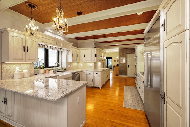 kitchen featuring pendant lighting, dishwasher, light stone countertops, light hardwood / wood-style floors, and kitchen peninsula