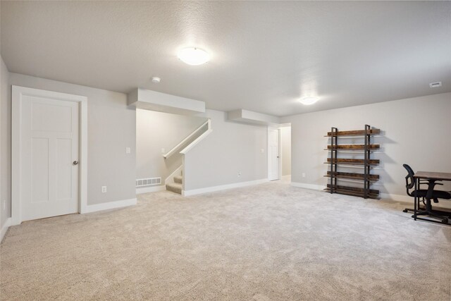 basement featuring carpet flooring and a textured ceiling