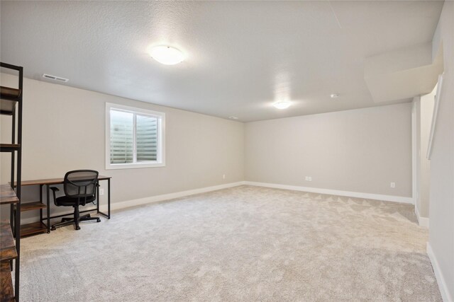 carpeted home office with a textured ceiling