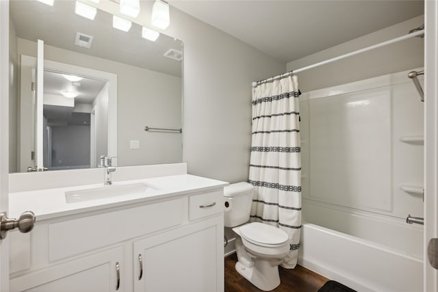 full bathroom featuring hardwood / wood-style floors, vanity, shower / bath combo, and toilet