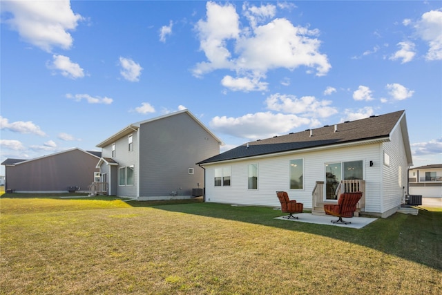 rear view of property featuring central AC unit, a patio area, and a yard