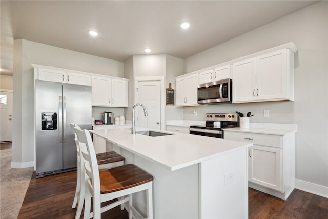 kitchen with a center island with sink, white cabinets, sink, and appliances with stainless steel finishes