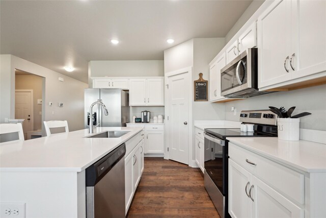 kitchen with white cabinetry, sink, dark wood-type flooring, a kitchen island with sink, and appliances with stainless steel finishes