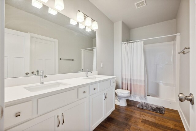 bathroom with a shower with curtain, hardwood / wood-style floors, vanity, and toilet