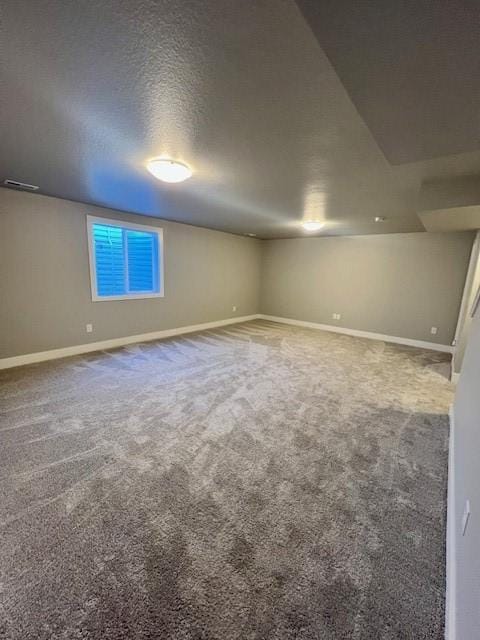 basement featuring a textured ceiling and carpet floors